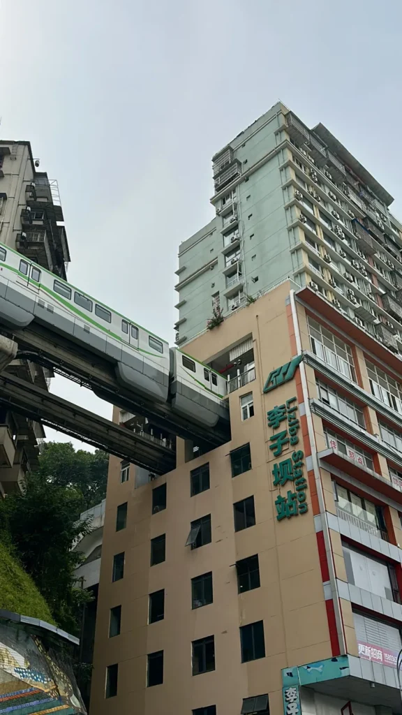 Tren del monorraíl entrando en un edificio de viviendas en la estación de Liziba