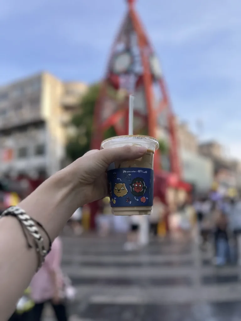 Mano sosteniendo un café con hielo de Luckin Coffee en una calle de Guilin