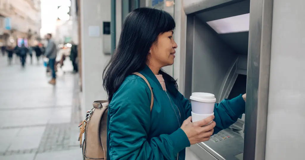 Mujer usando cajero automático en calle